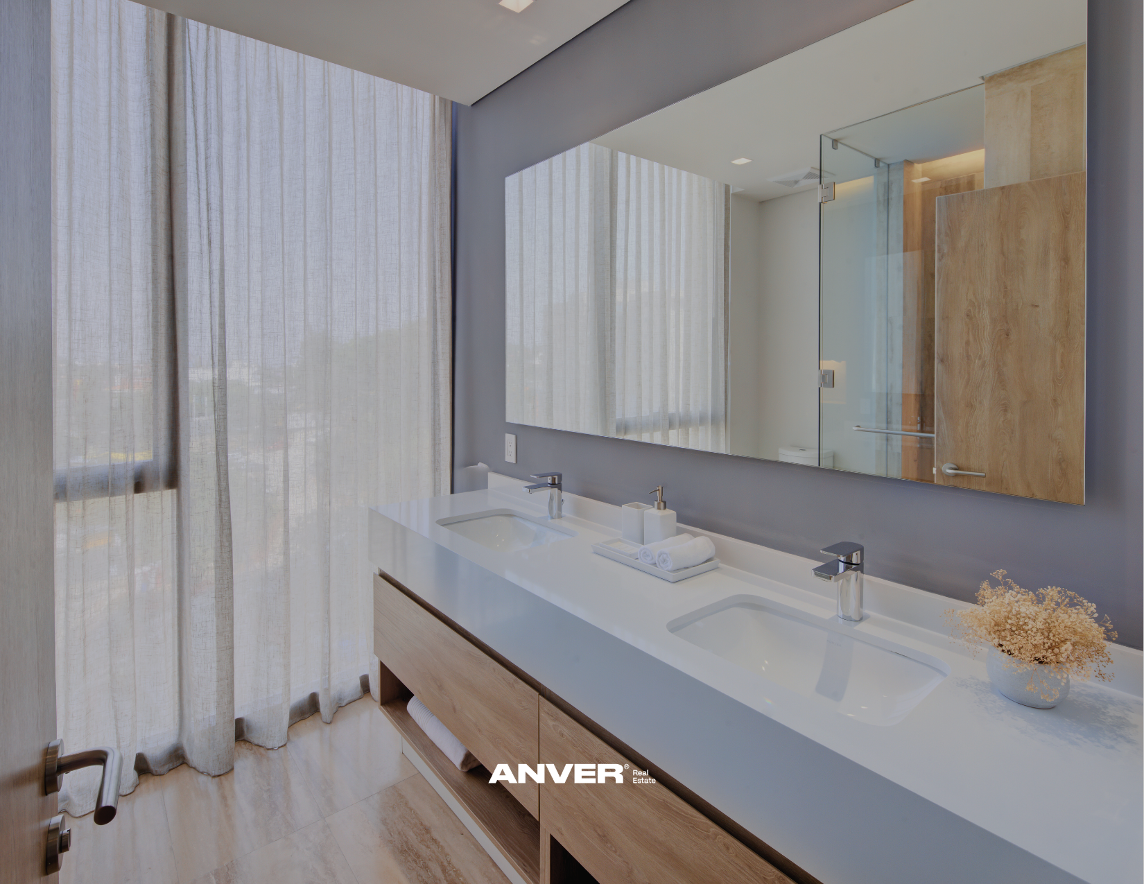 Lavabo doble con espejo grande y cortinas de tela ligera en un baño moderno con madera y tonos neutros.