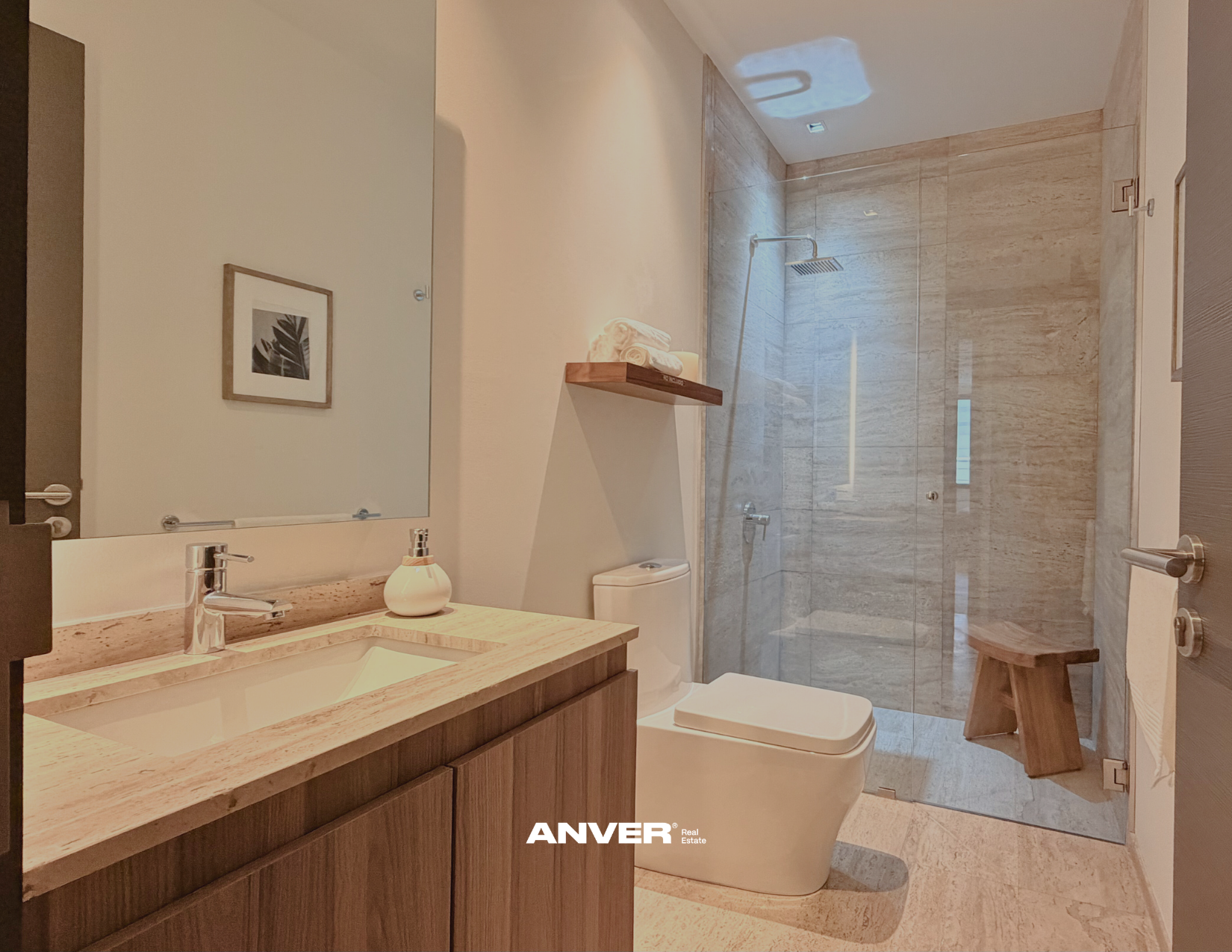 Baño moderno con lavabo de madera, espejo grande, ducha con puertas de cristal, inodoro y taburete de madera