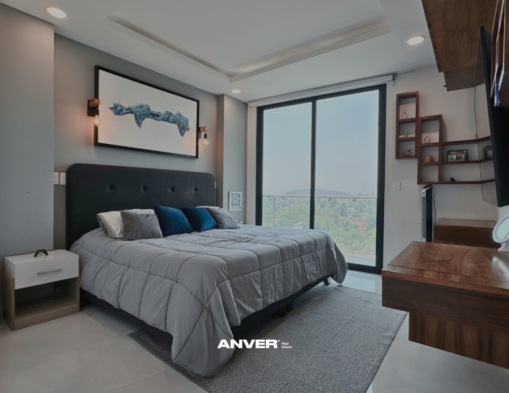 Habitación moderna con cama grande, ventana con vista a la ciudad y decoración en tonos neutros y azules.