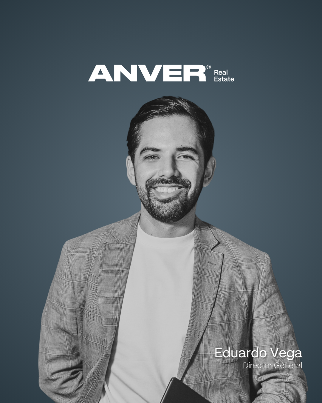 Retrato en blanco y negro de un hombre sonriendo, vestido con saco y camiseta blanca, con texto que dice Eduardo Vega y Director General, con fondo azul y logotipo de ANVER Real Estate.