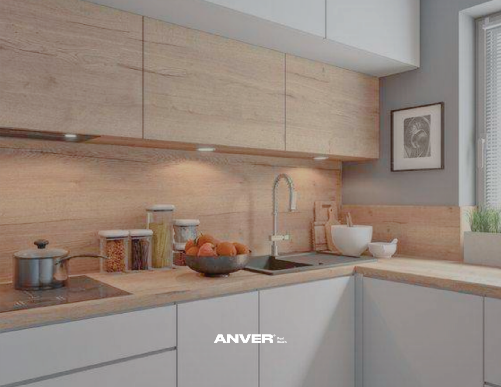 Cocina moderna con gabinetes blancos, encimera de madera, fregadero con grifo, utensilios de cocina, frascos con ingredientes y un cuenco con frutas, cerca de una ventana con plantas y una obra de arte en la pared.