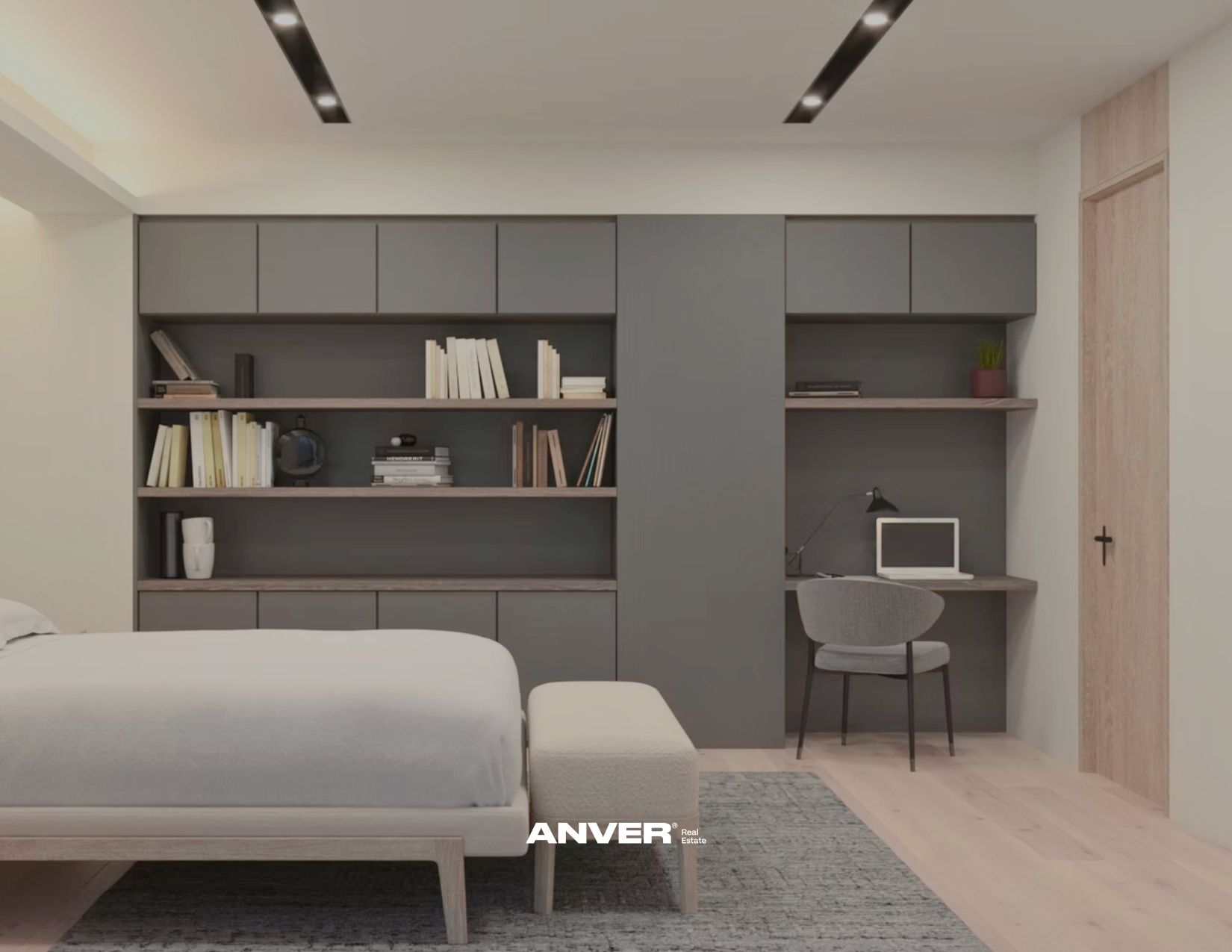 Sala moderna con estanterías grises llenas de libros, mesa de oficina con computadora y silla, y un sofá beige. Piso de madera clara y paredes blancas. Logo de 'ANVER' en la parte inferior.
