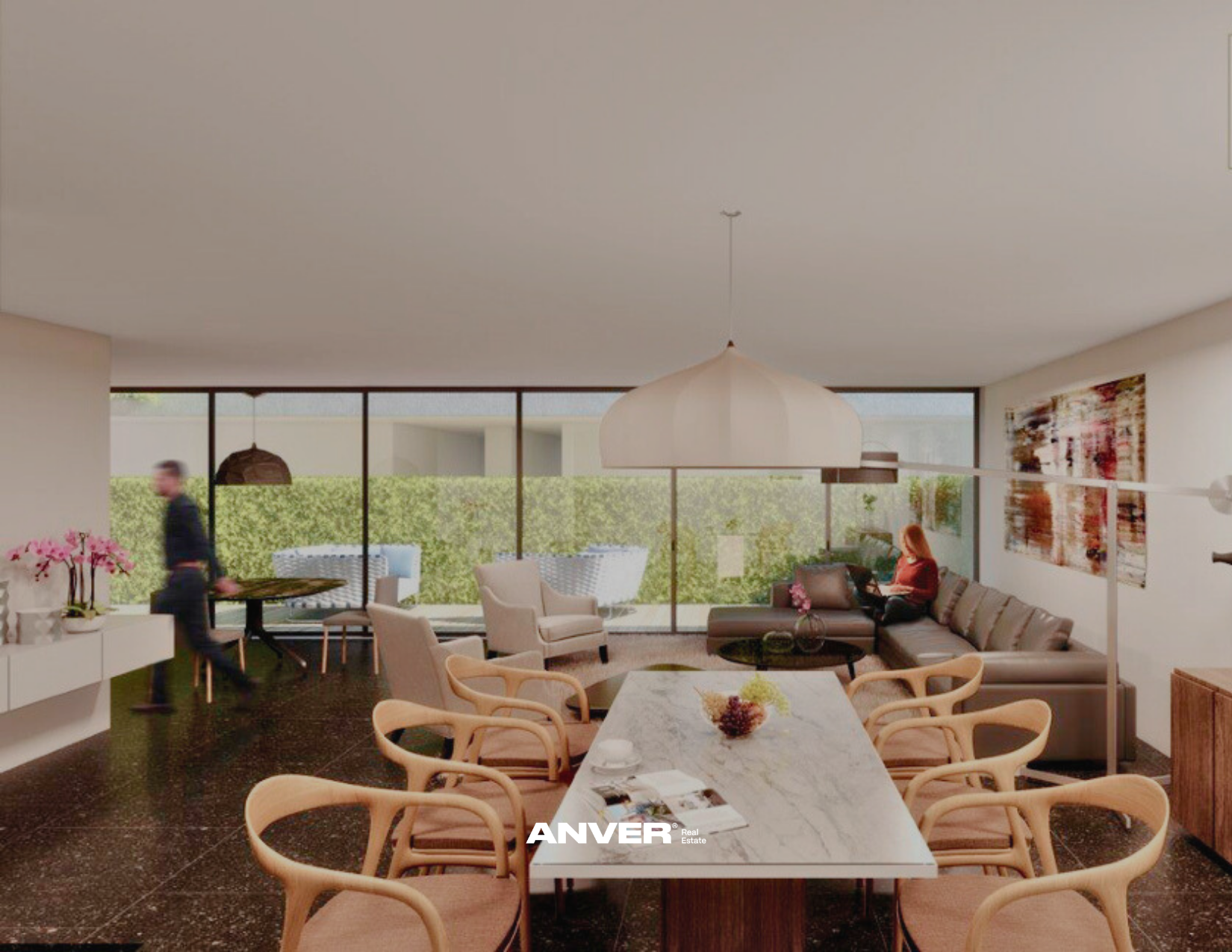 Sala de estar moderna con grandes ventanales, muebles beige y una mujer sentada en un sofá leyendo, decoraciones florales y una lámpara colgante