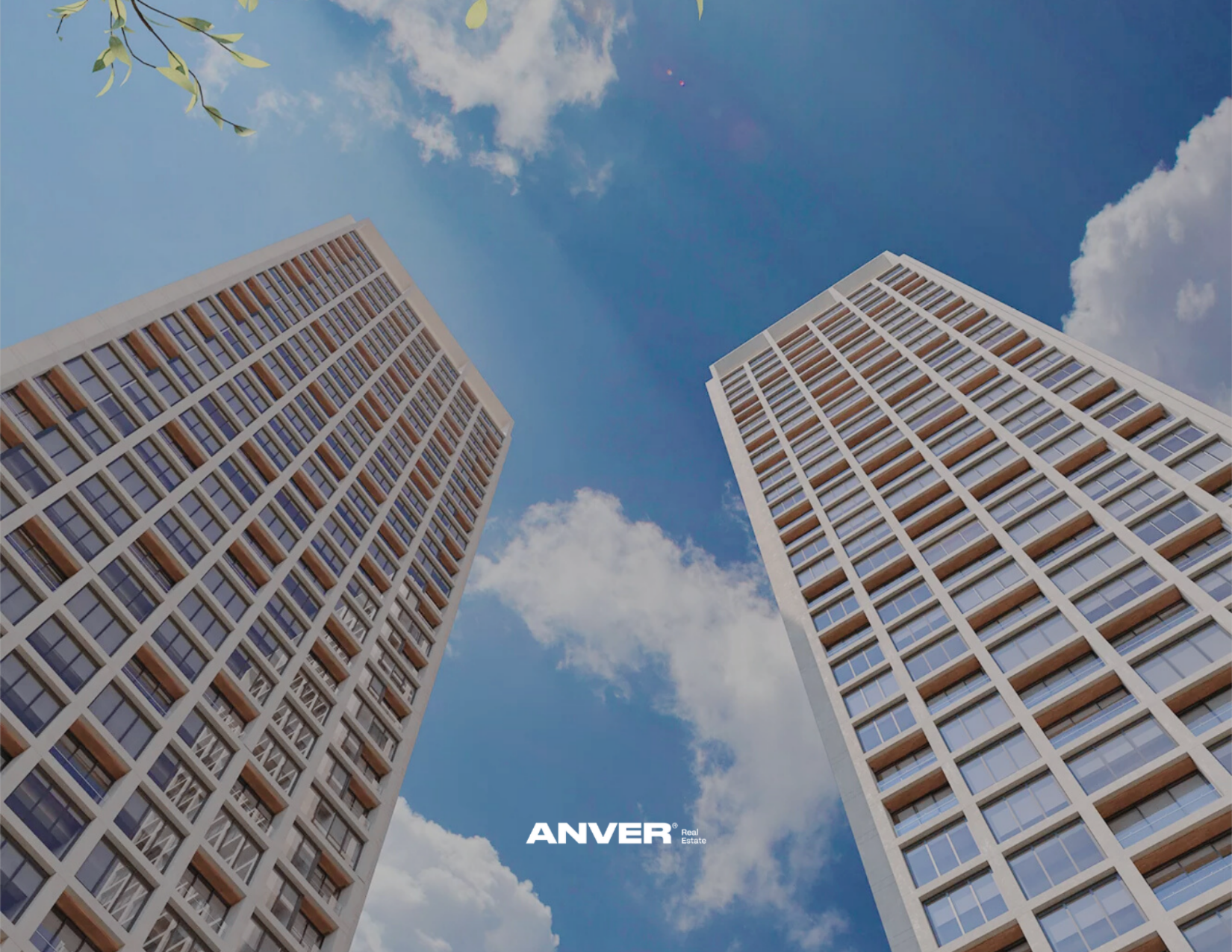 Dos edificios altos de oficinas o apartamentos con ventanas de cristal y balcones de madera, vistos desde abajo hacia el cielo azul con algunas nubes y ramas de árbol en la esquina superior izquierda. En el centro, se lee 'ANVER Real Estate'.