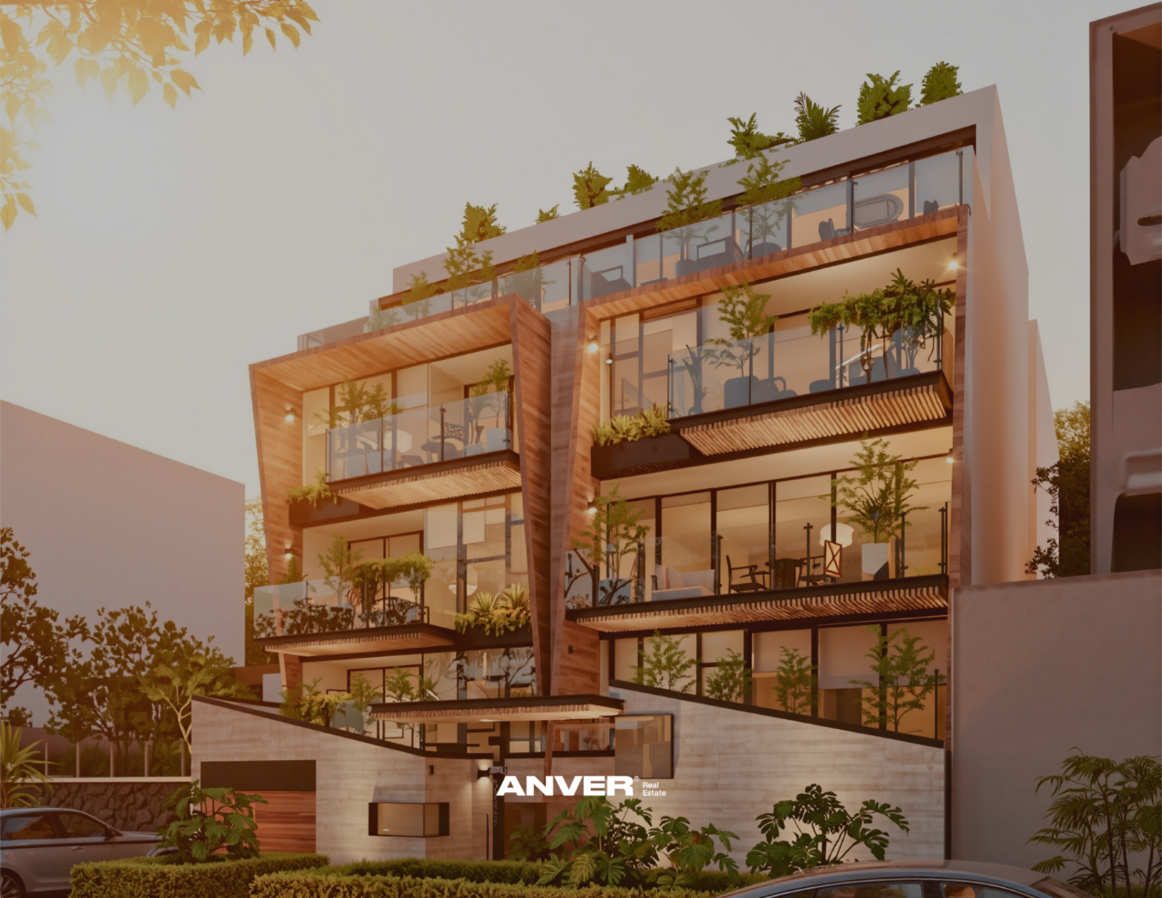 Vista de un edificio moderno de varios pisos con balcones de vidrio y plantas verdes, durante el atardecer, con árboles y autos en primer plano.