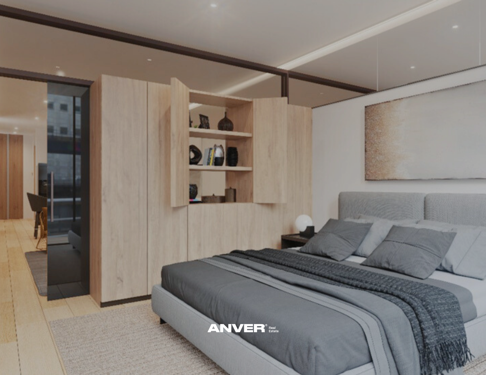 Habitación moderna con cama king size, paredes decoradas con arte abstracto, pared divisoria de madera con estantería y zona de trabajo visible al fondo