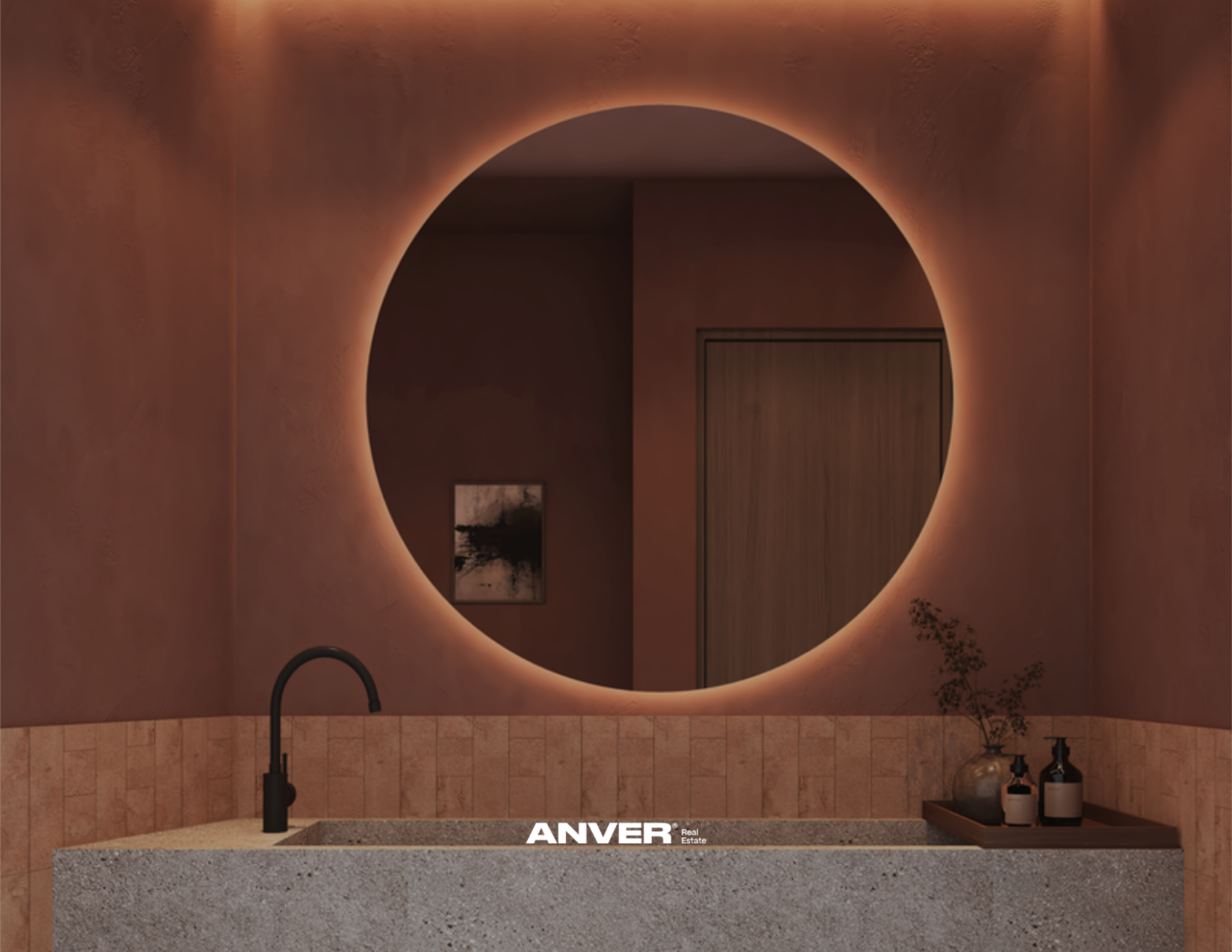 Un espejo de pared con luz ambiental detrás, un lavabo de granito con grifo negro y algunos frascos, una pared de azulejos en tonos beige y un cuadro abstracto en la pared. La imagen tiene texto en la parte inferior que dice 'ANVER'.