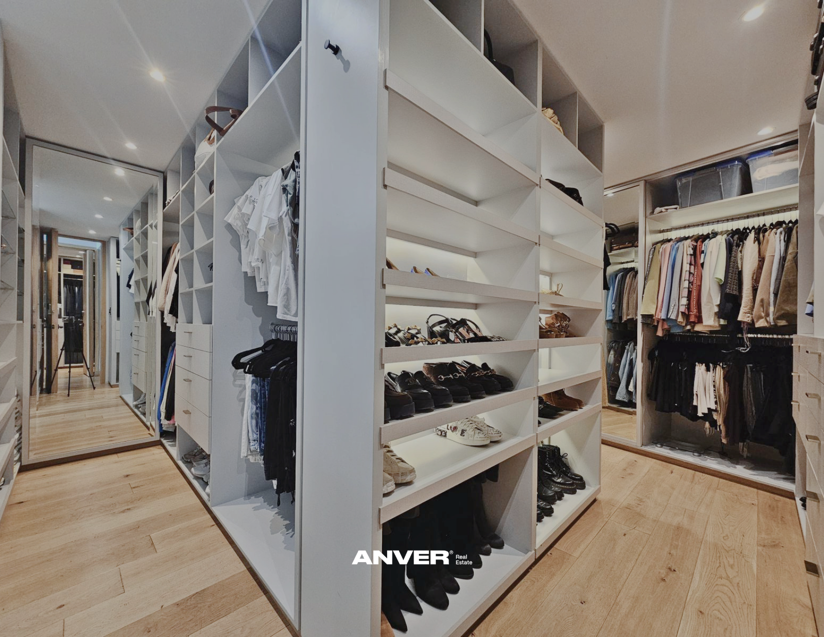 Vestidores con estantes llenos de ropa, zapatos y accesorios en una tienda o walk-in closet moderno.