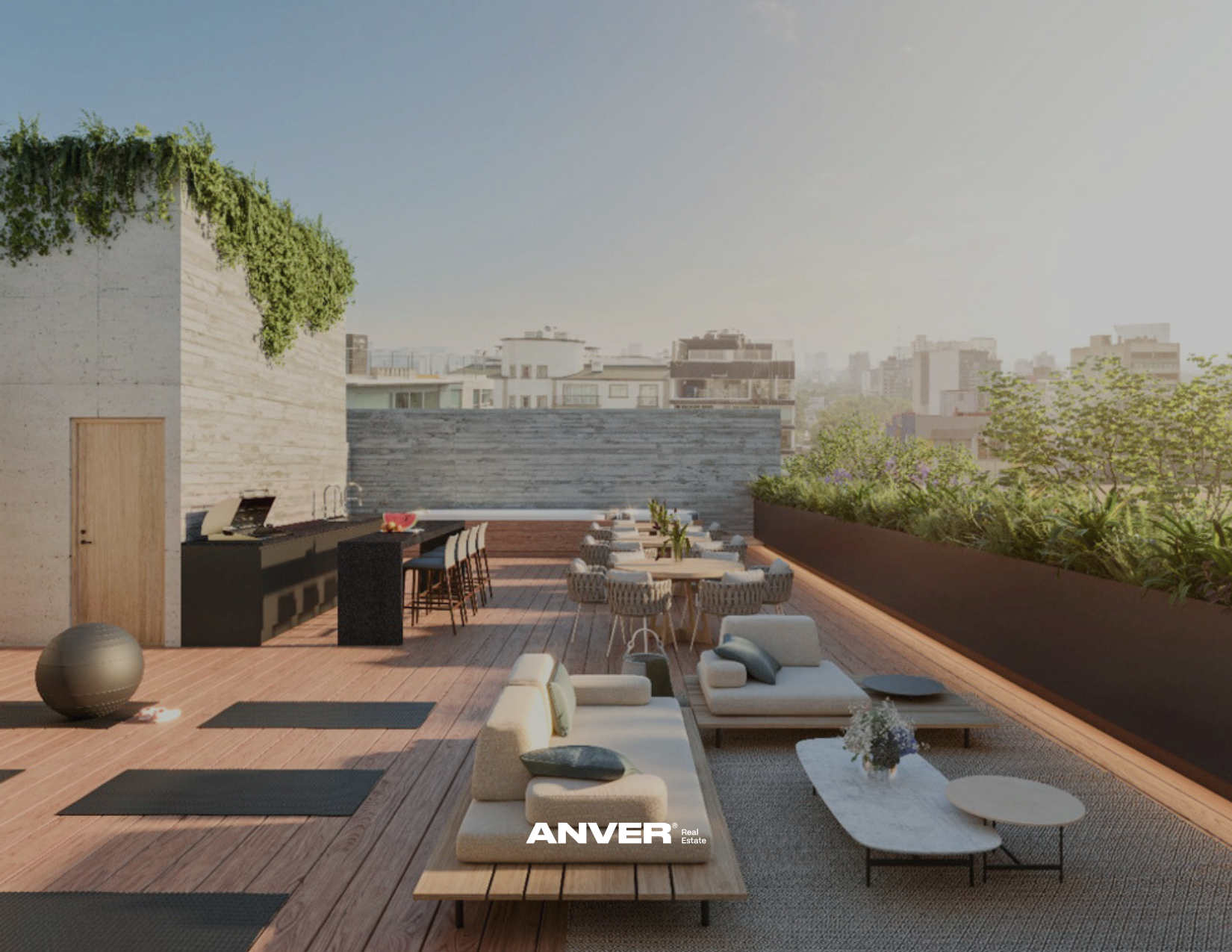 Terraza en un edificio urbano con mobiliario de exterior, incluyendo sillones, mesas y una barra con sillas, rodeada de plantas y con vista a la ciudad.