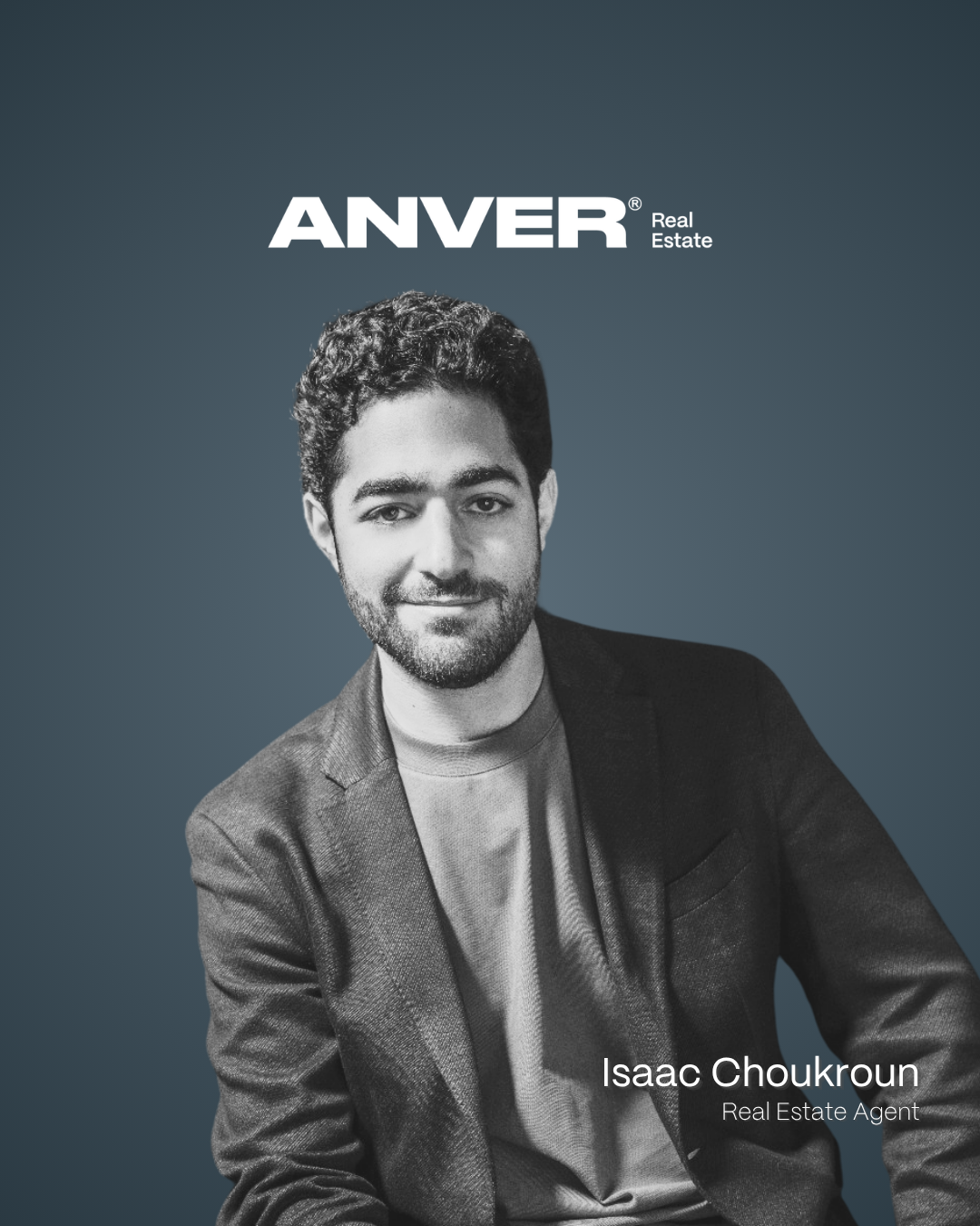 Foto en blanco y negro de un hombre con barba y cabello rizado, vestido con saco y camiseta gris, sentado sonriendo. Texto sobre fondo azul oscuro que dice 'ANVER Real Estate' y en la esquina inferior derecha 'Isaac Choukroun, Agente de Bienes Raíces'.