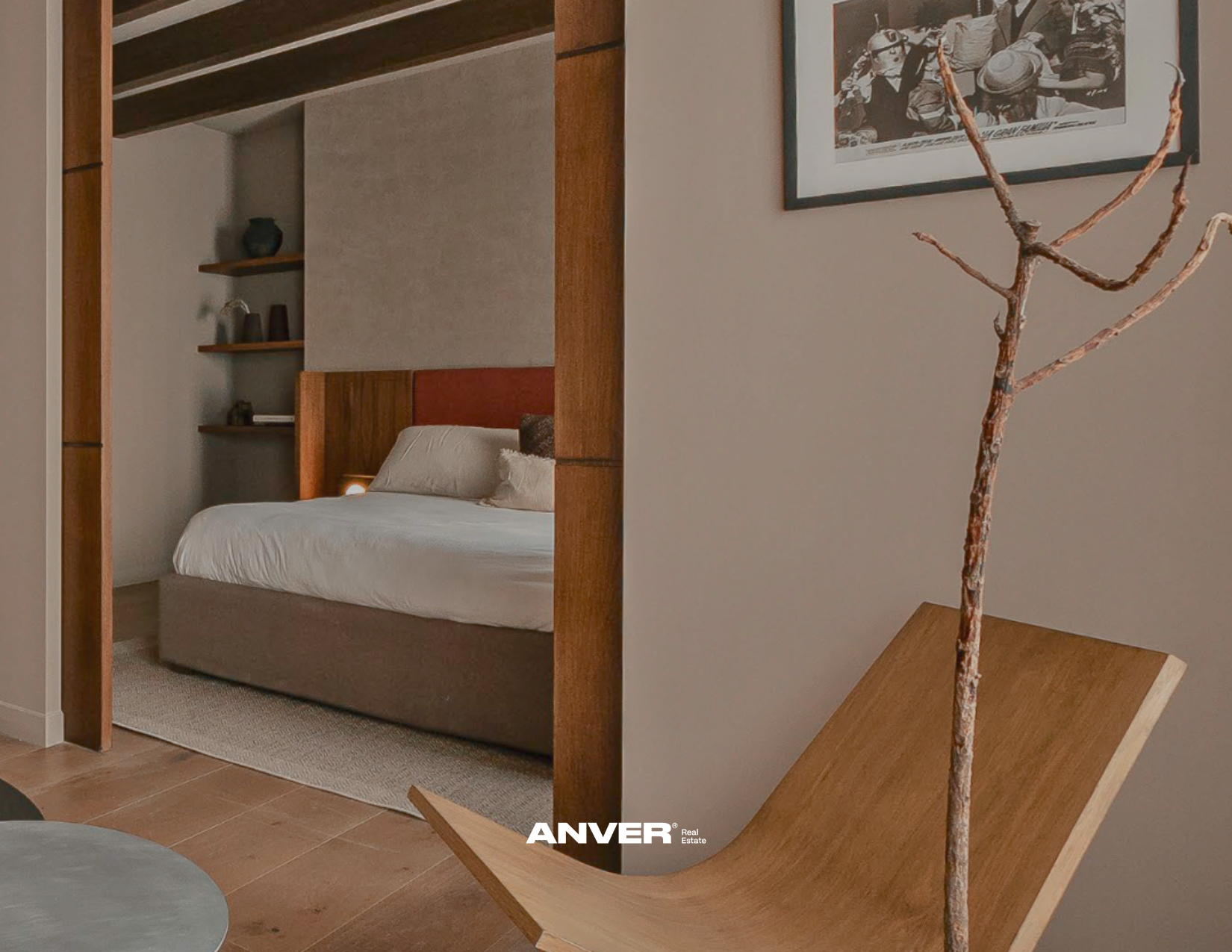 Habitación moderna con cama blanca, estanterías de madera y una silla de madera con diseño curvo en la esquina.
