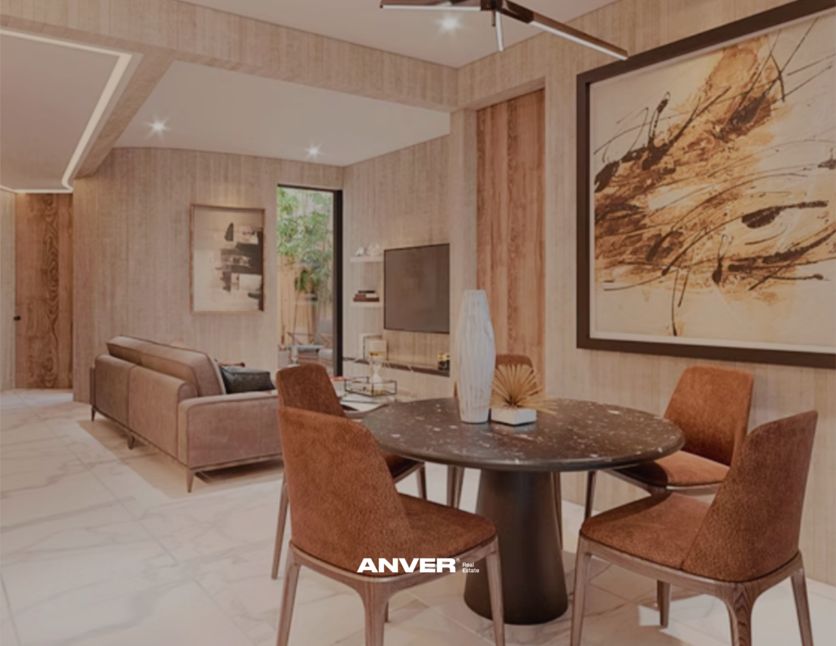 Sala de estar y comedor con paredes de madera clara, sillón beige y mesa de comedor redonda con sillas anaranjadas, decorada con jarrón y libros. Hay arte en las paredes y una televisión en un mueble, con una planta cerca de la ventana.