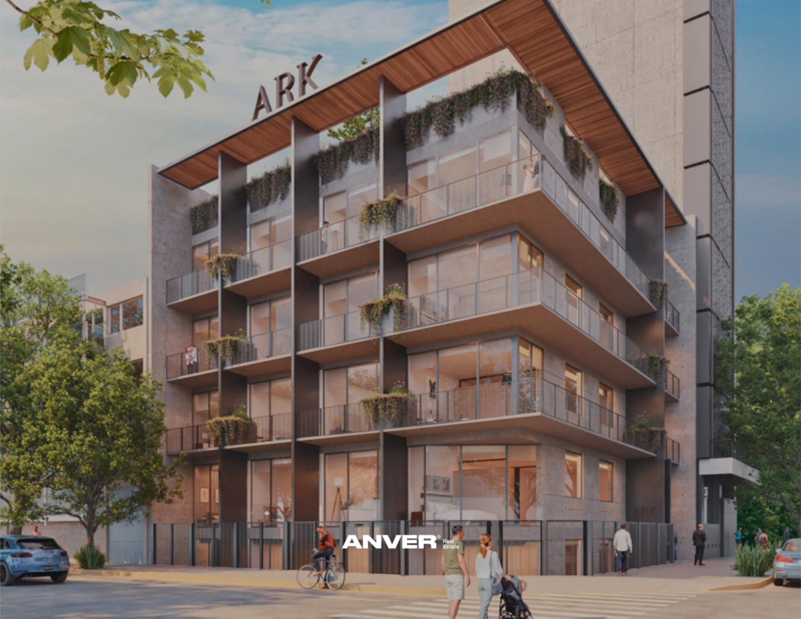 Edificio moderno de varios pisos con terrazas, plantas y un letrero que dice 'ARK' en la azotea, en un entorno urbano con árboles y personas en la calle.