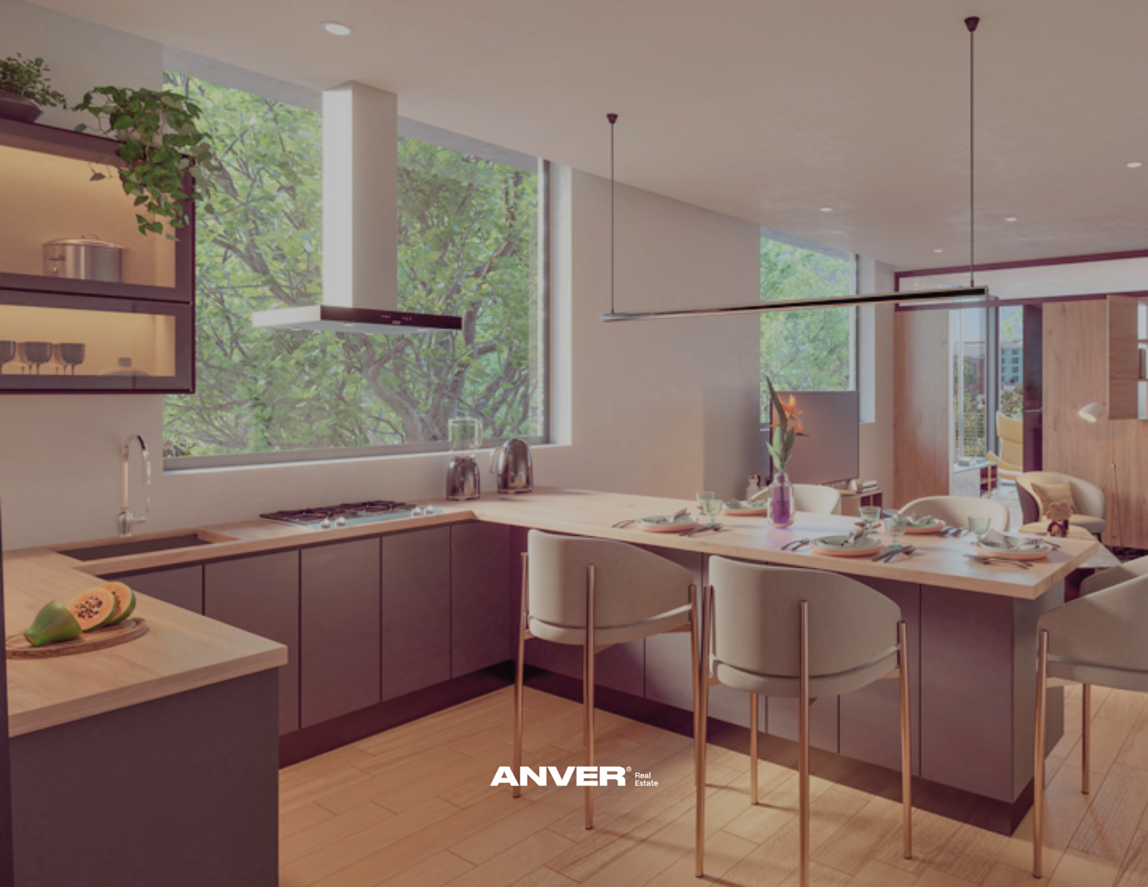 Cocina moderna con isla de madera, paredes con ventanas grandes y vista a árboles verdes, mesa para comer con platos y vasos, sala con sillones y tv al fondo.