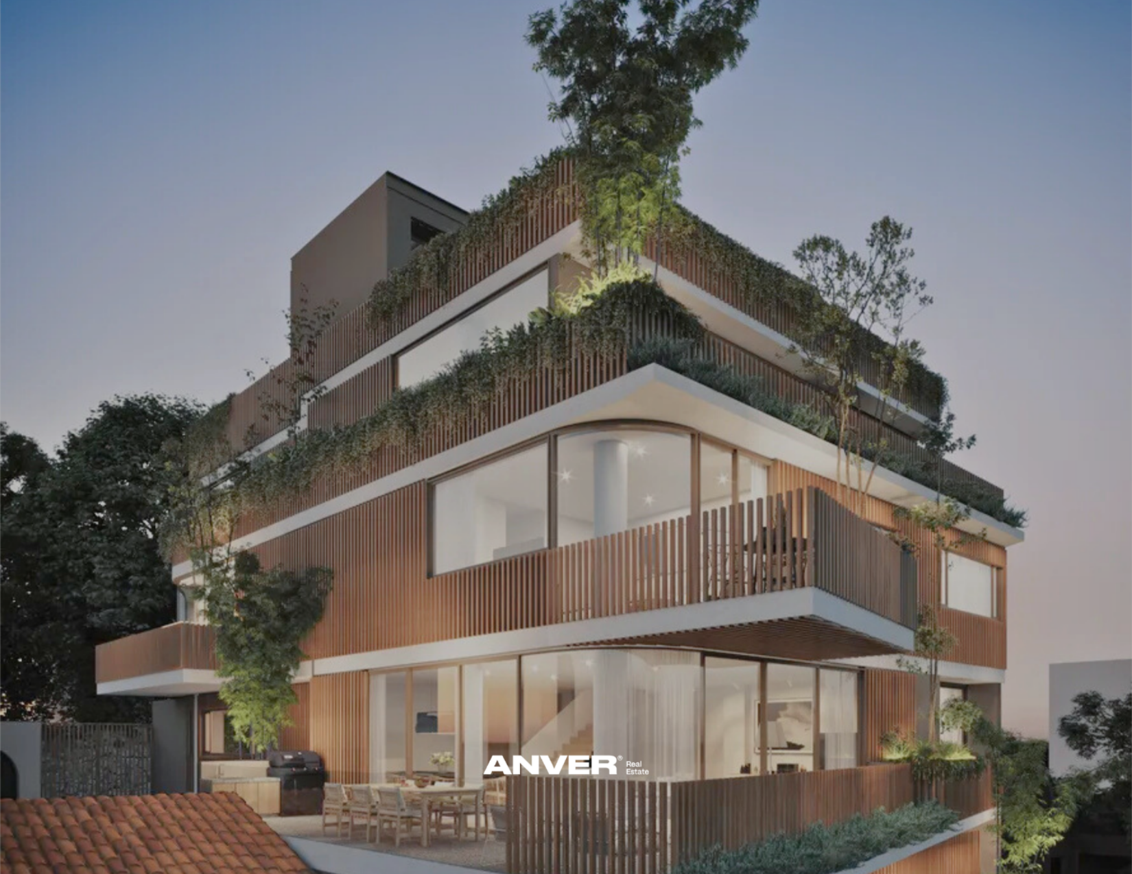 Edificio moderno con varias plantas, terrazas con plantas y árboles, grandes ventanas y madera en el diseño, iluminado al atardecer.