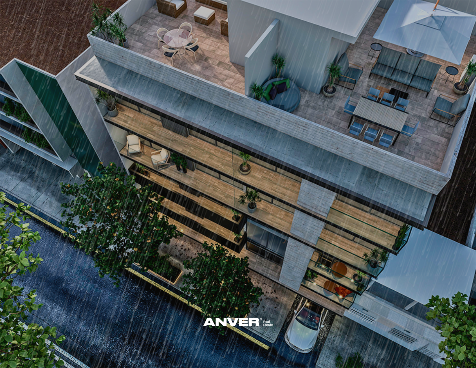 Vista aérea de un edificio moderno con terraza y áreas al aire libre, con lluvia, plantas y mobiliario en el techo y en el balcón. Se observa también un río cercano y un área de estacionamiento.