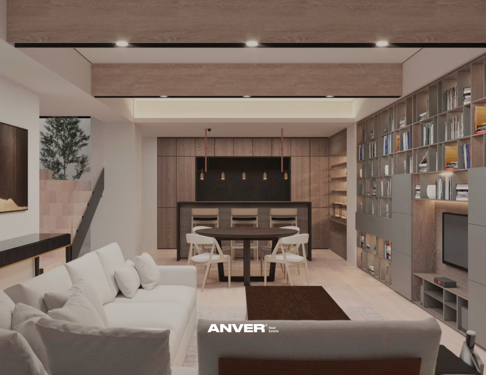 Sala de estar moderna con sofá blanco, mesa redonda, estantería con libros y una cocina en el fondo.