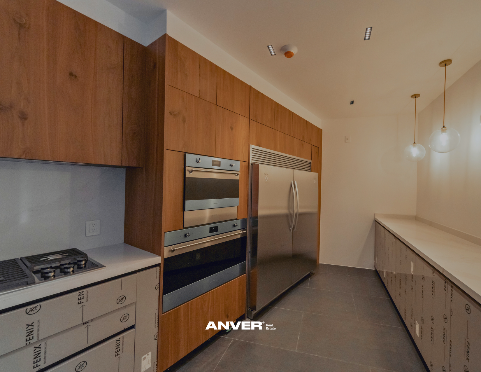 Cocina moderna con electrodomésticos de acero inoxidable y armario de madera.