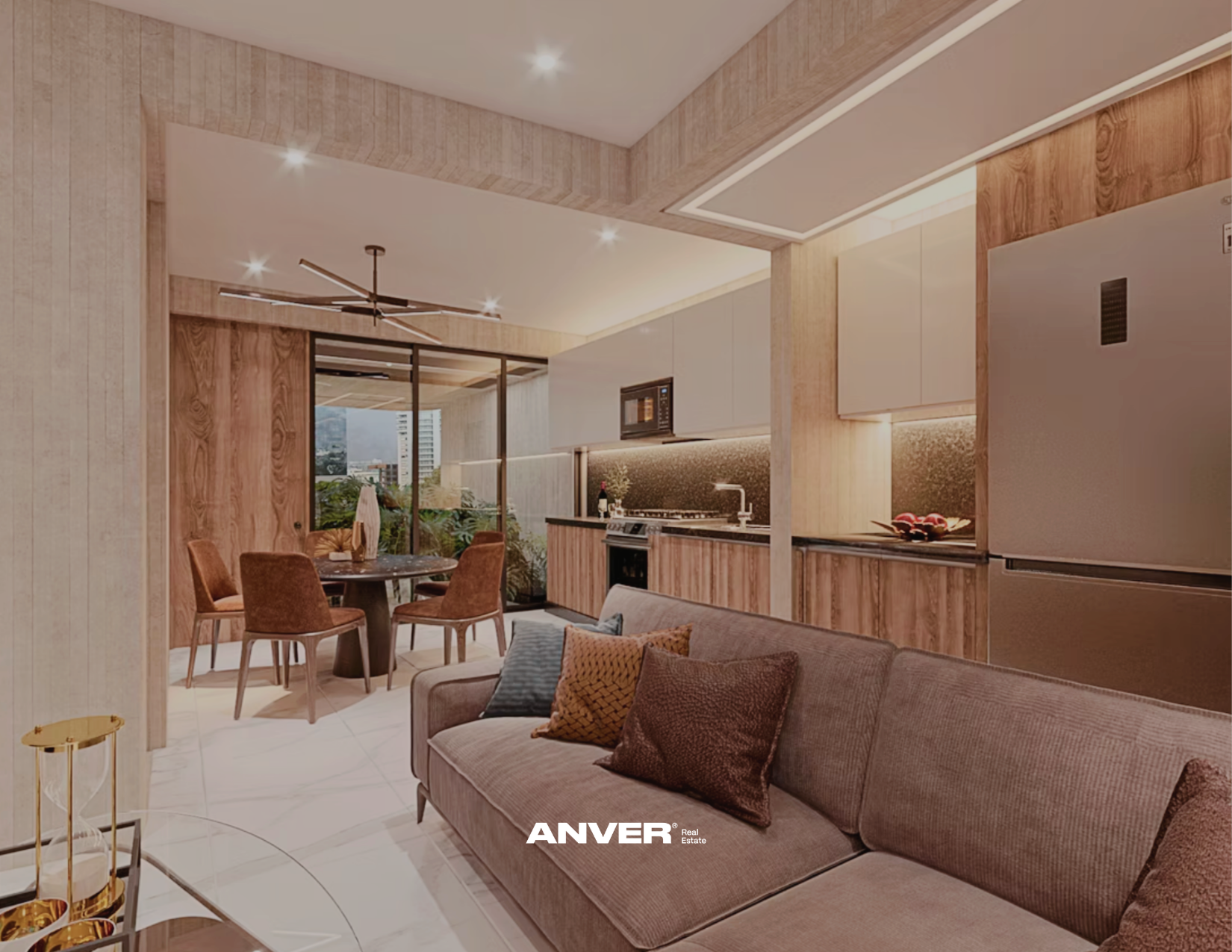 Sala de estar moderna con sofá gris y cojines, comedor con mesa redonda y sillas de terciopelo, cocina con gabinetes blancos y detalles de madera, ventanas con vista a edificios y naturaleza, iluminación empotrada en el techo.