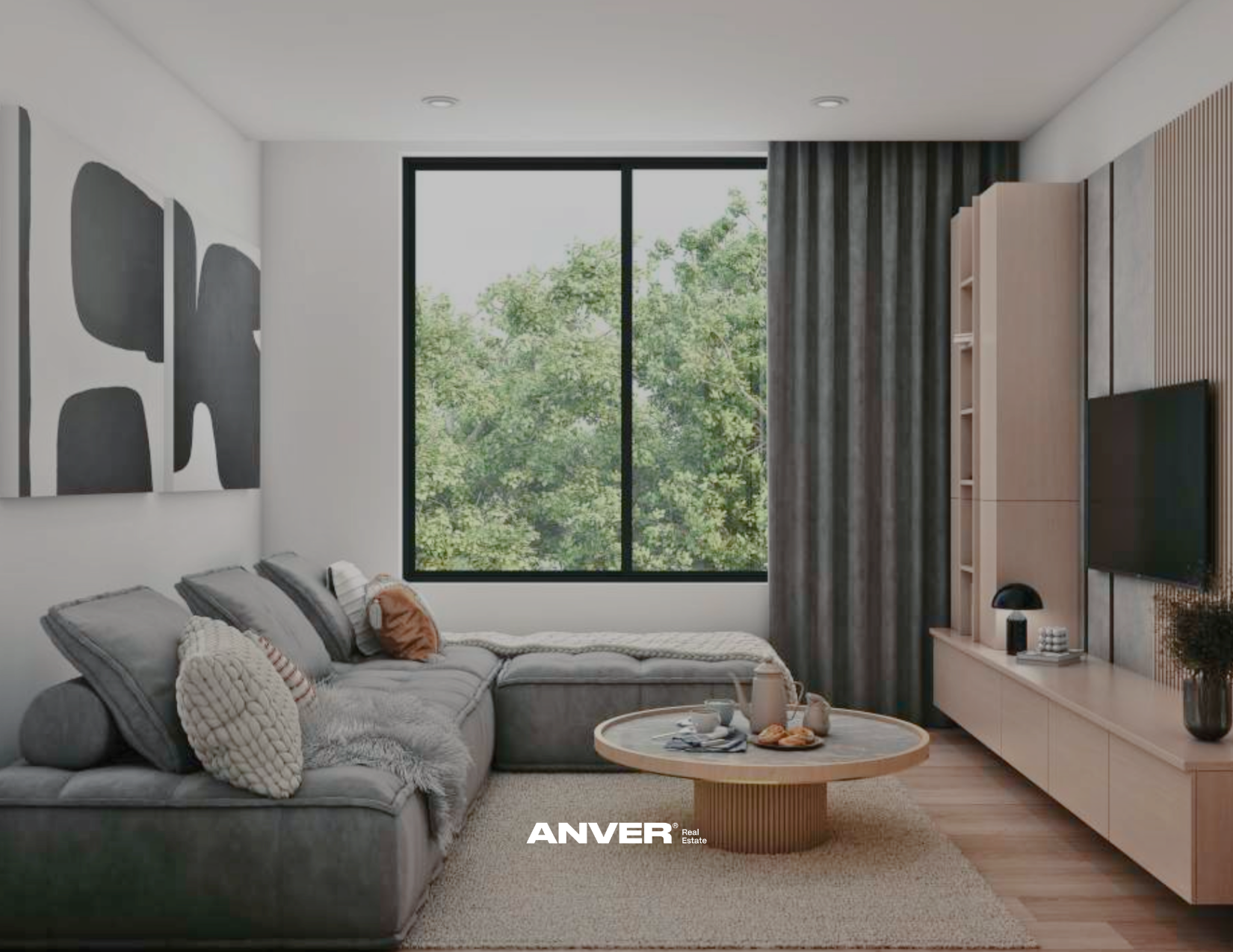 Sala moderna con sillón gris claro, mesa de centro de madera, pared decorada con arte abstracto en tonos grises y blancos, ventanas grandes con vista a árboles verdes, cortinas gris oscuro, muebles de madera clara y televisor en la pared.