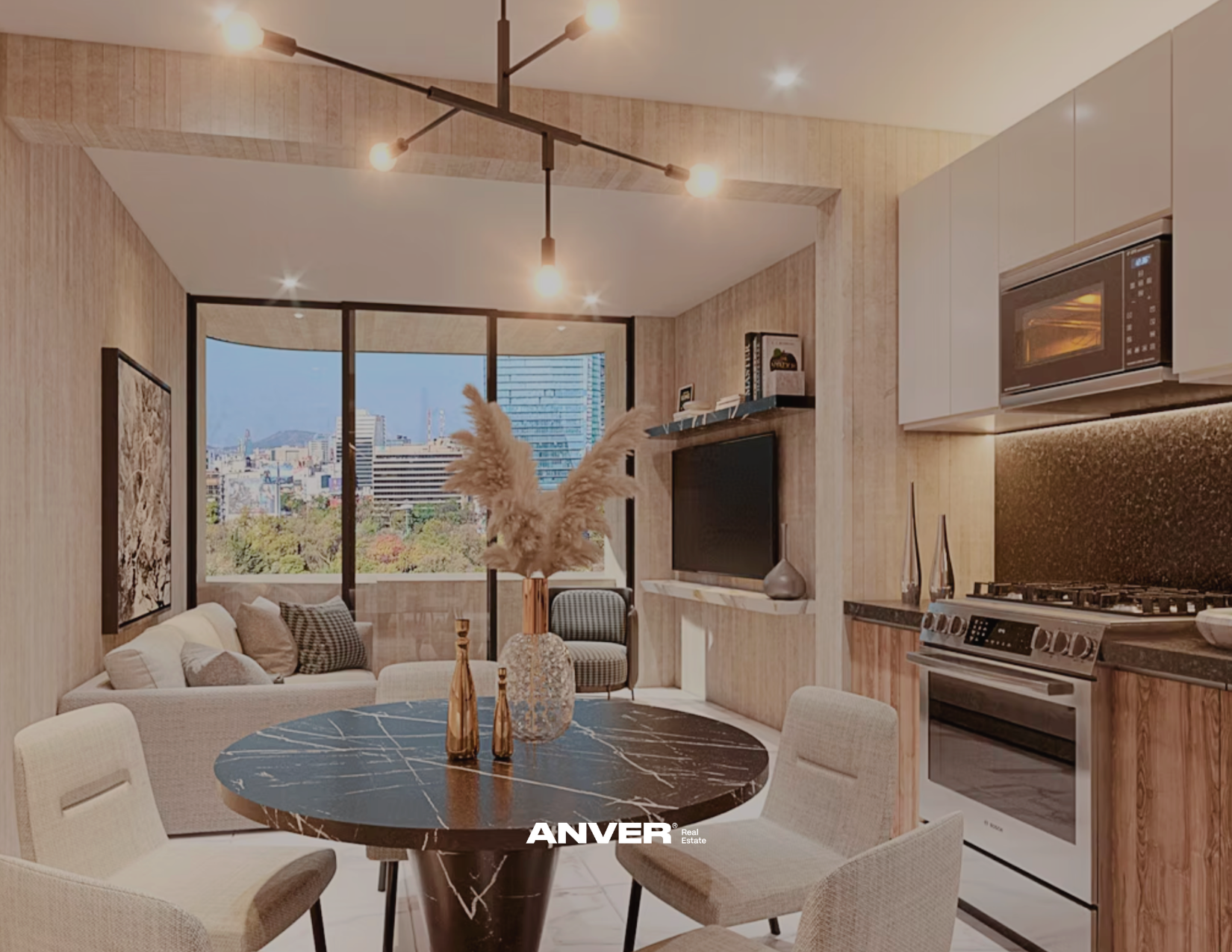 Sala moderna con mesa redonda de mármol negro, sillas beige, sofá gris con cojines, paredes de madera, ventana grande con vista a la ciudad, cocina con estufa y microondas, decoración con cuadros y jarrones.