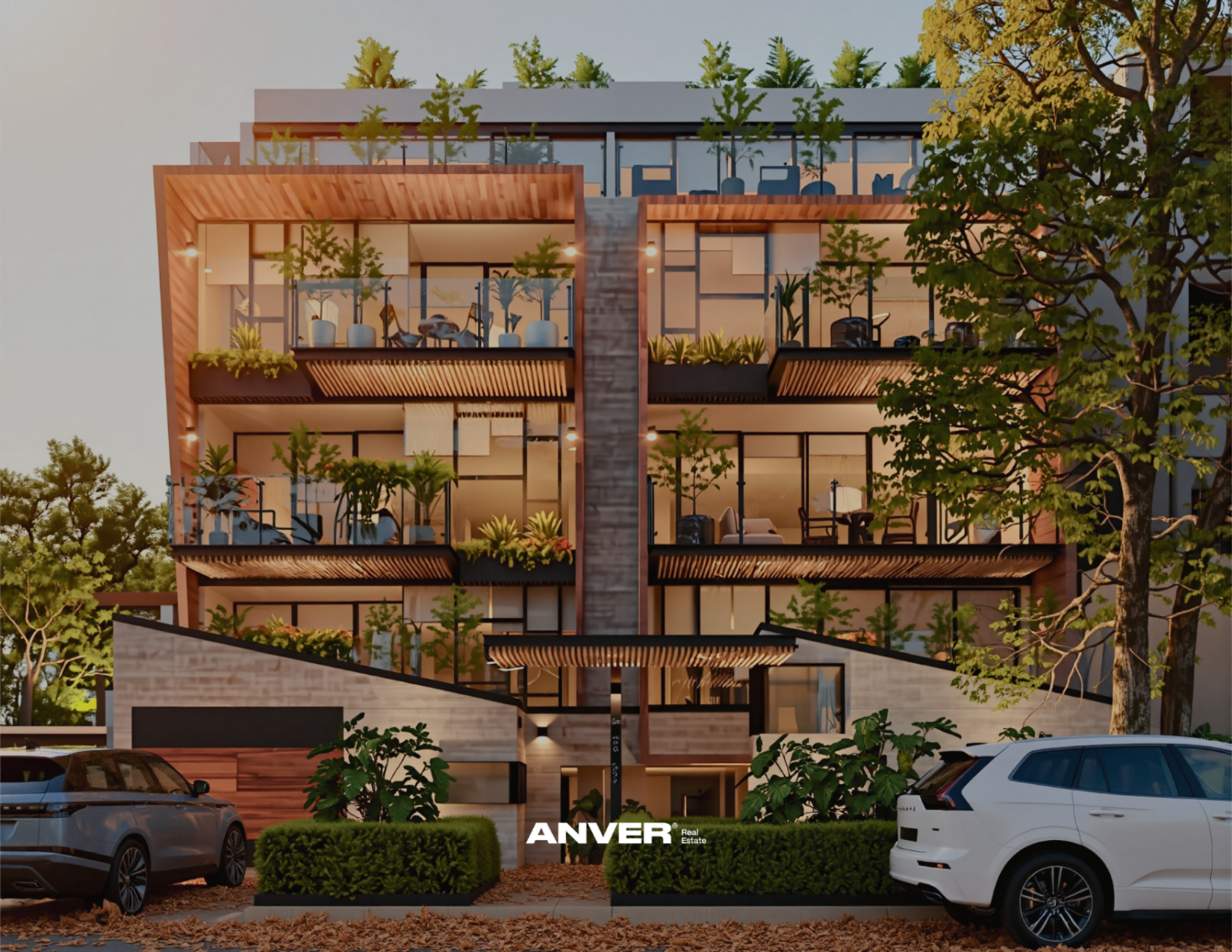 Edificio residencial de varios pisos con balcones llenos de plantas y muebles de exterior, rodeado de árboles y autos estacionados en la calle.