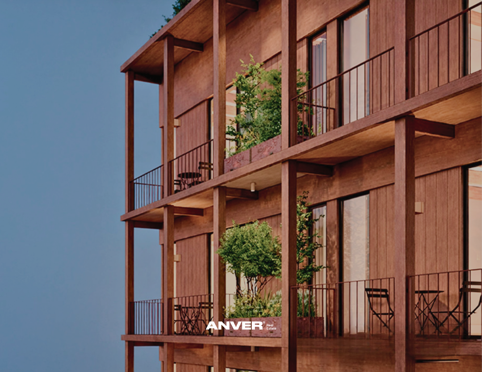 Edificio de apartamentos de madera con balcones y plantas en las terrazas, contra un cielo azul.