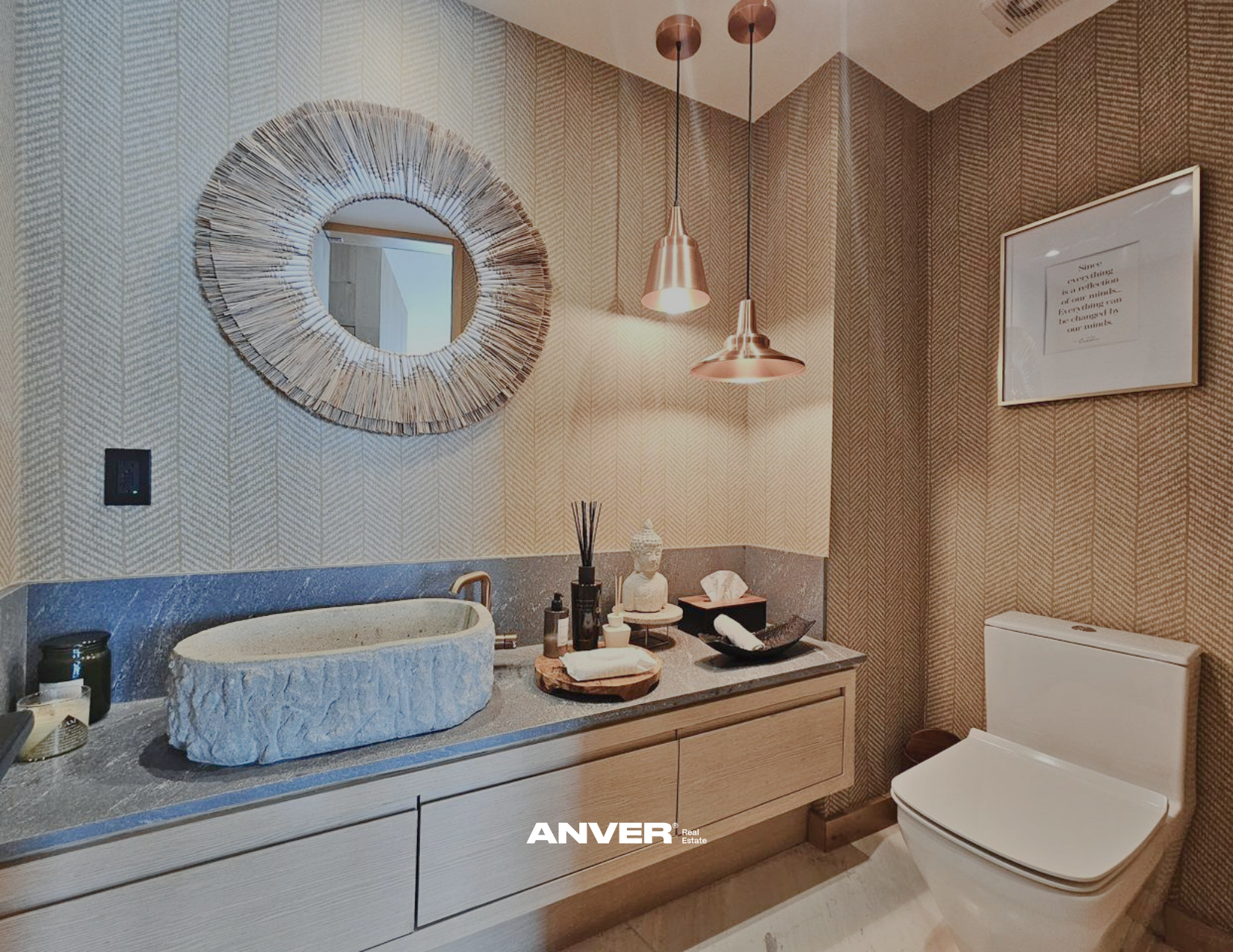 Un baño moderno con espejo decorativo, lavabo de piedra, y accesorios de decoración como figura de Buda y velas. Incluye espejo redondo y lámparas colgantes.
