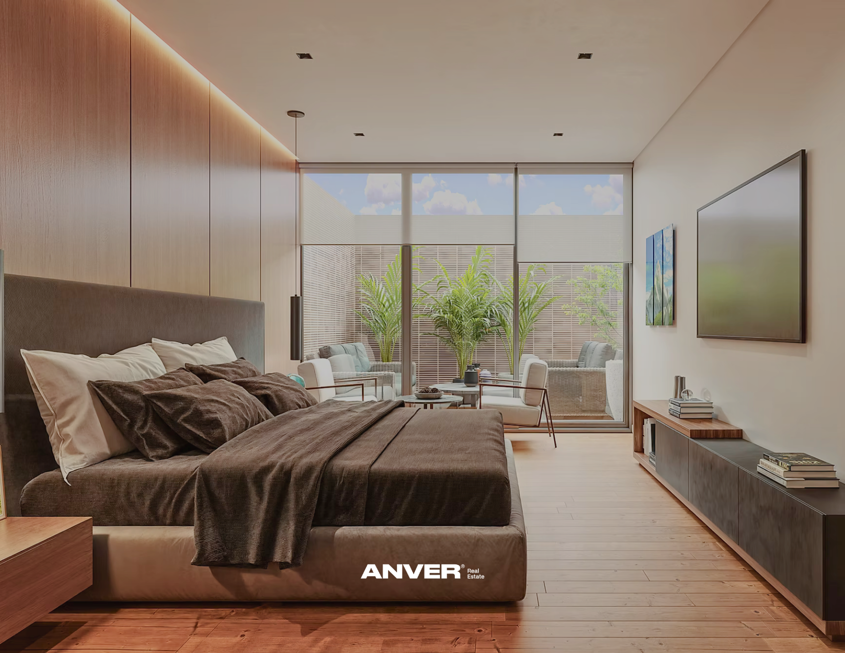 Dormitorio moderno con cama grande, colchas color café, ventanas grandes con vista a un balcón con plantas y mobiliario, pared de madera, televisión en la pared, muebles de almacenamiento y pisos de madera.