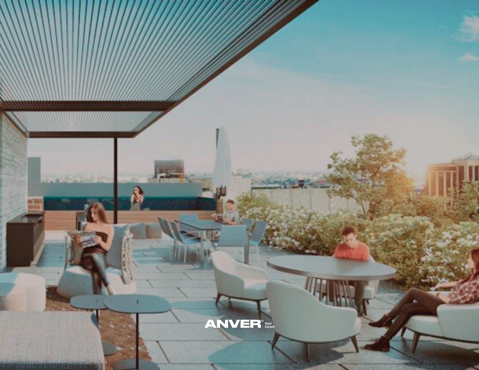Terraza de un edificio con varias personas sentadas y leyendo, rodeada de árboles y con vista a la ciudad al atardecer.