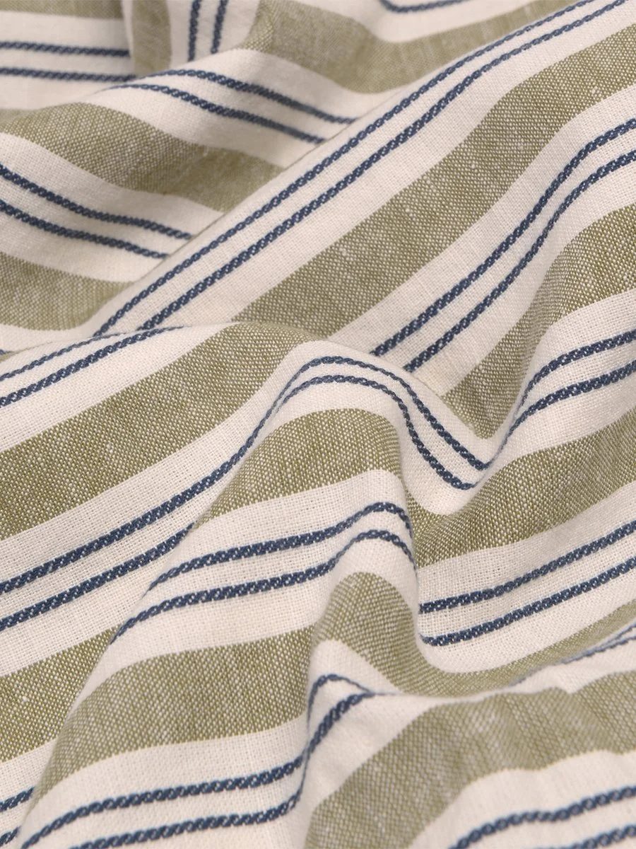 Close-up of fabric with green and white stripes and thin dark blue lines.
