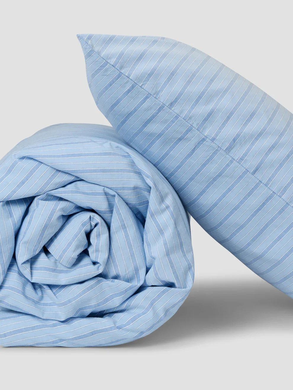 Two light blue striped bedding pieces, one folded and one laid flat.