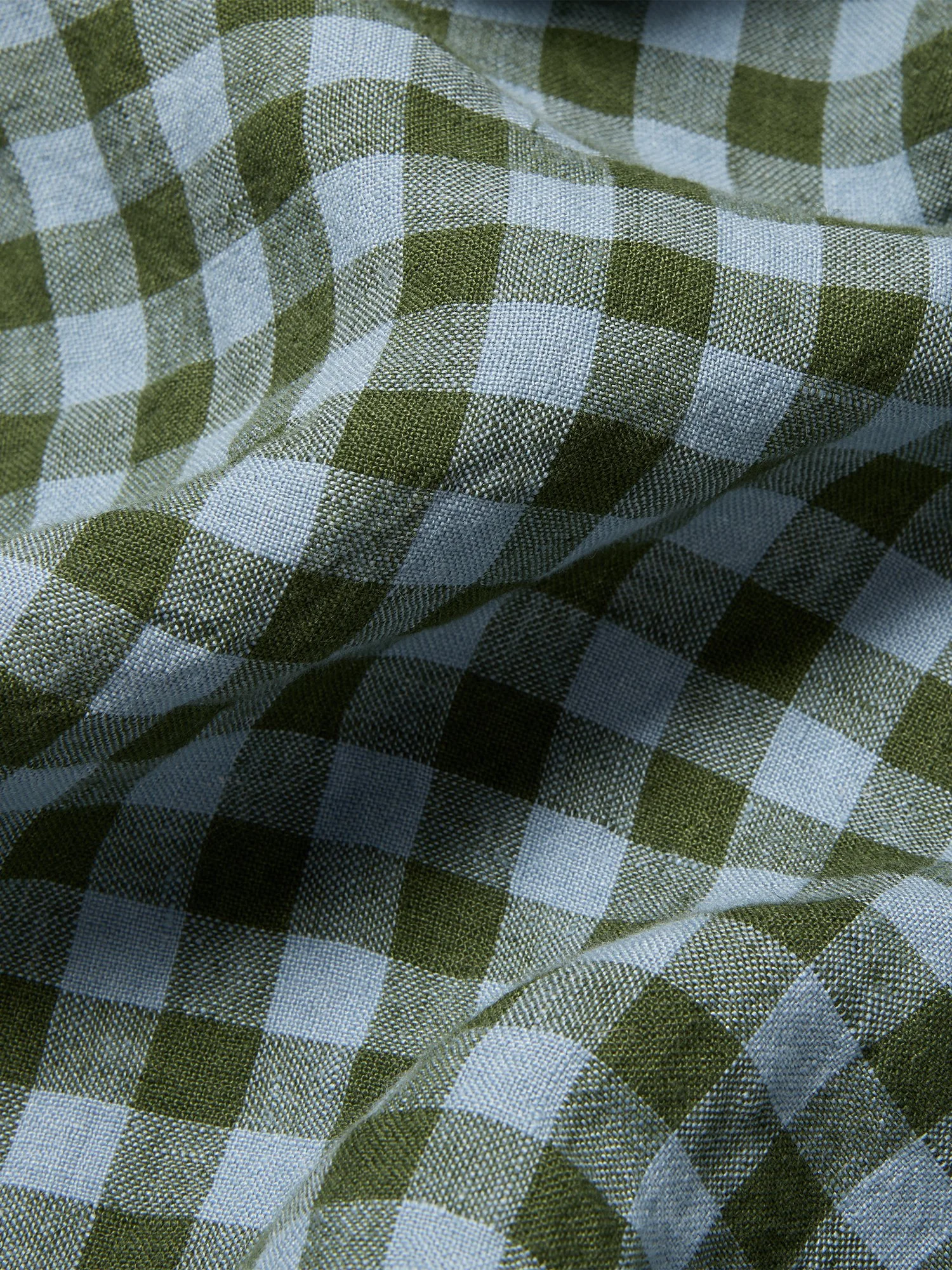 Close-up of green and white checkered fabric with a textured weave.