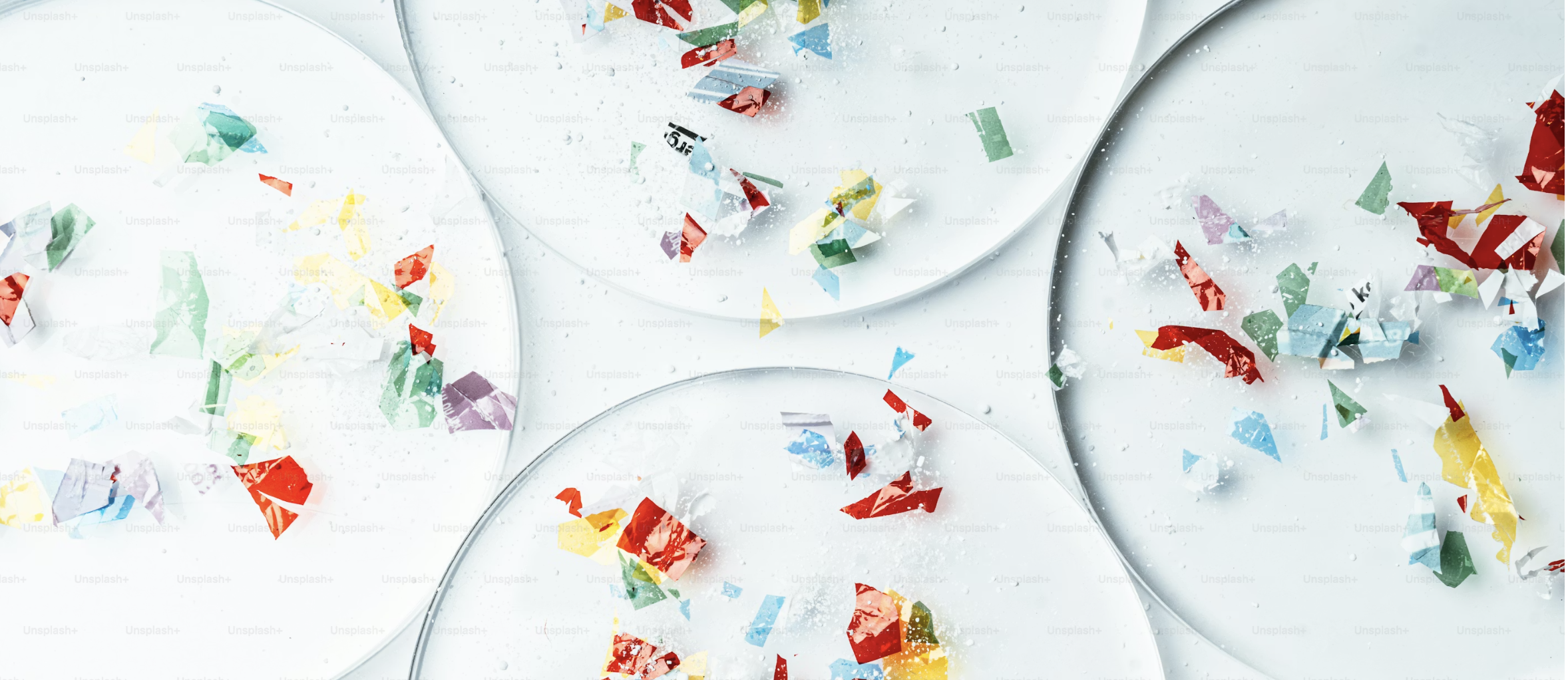 Colorful confetti scattered on clear plastic petri scientific discs