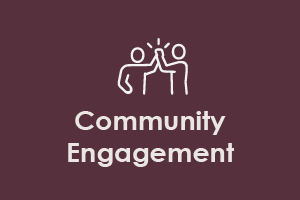 Icon of two people with raised hands above a table, symbolizing community engagement, against a dark maroon background.