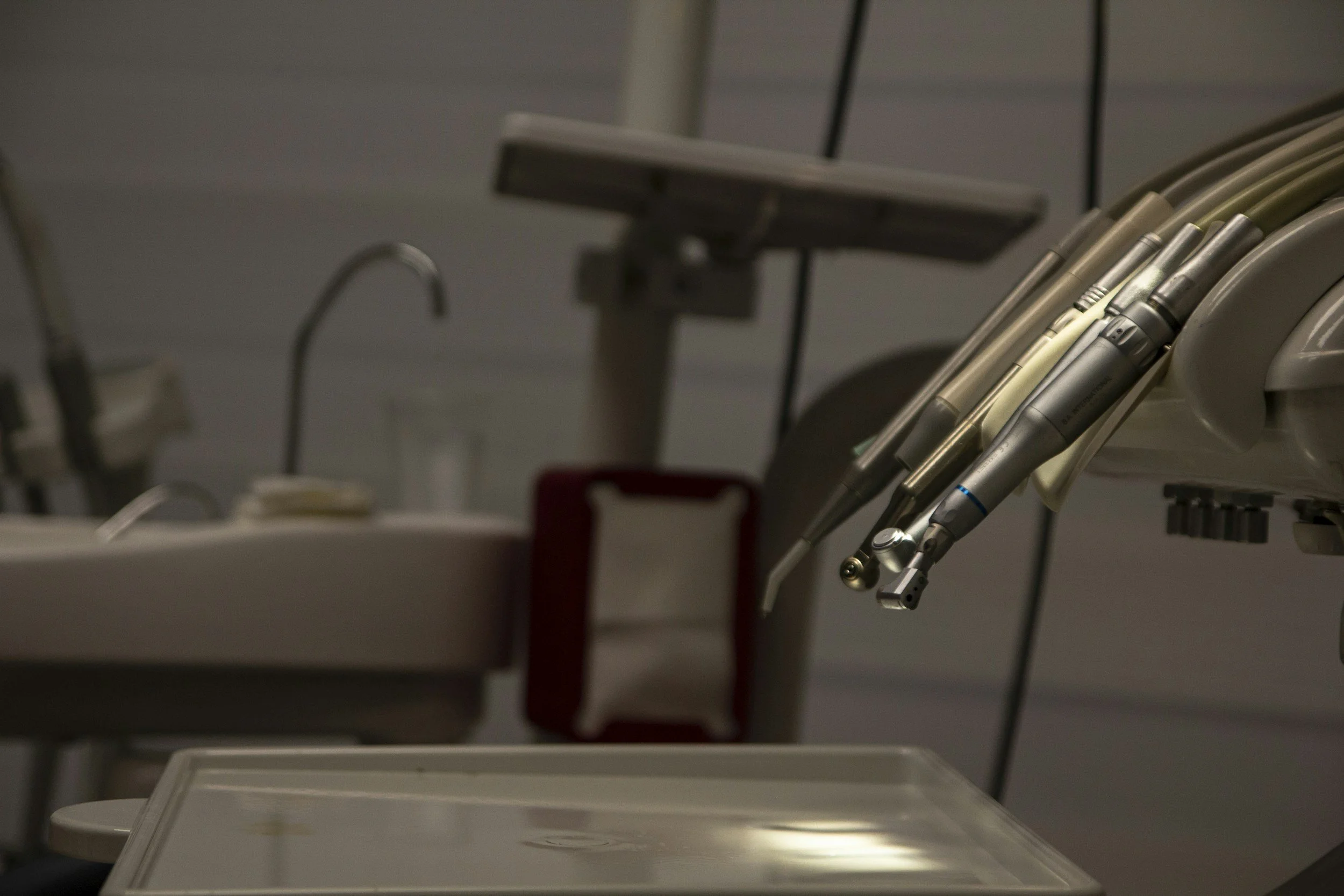 Close-up of dental tools on a tray in a clinical setting.
