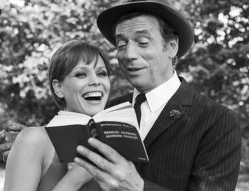 Un couple souriant dans un parc lisant un livre ensemble, en noir et blanc.