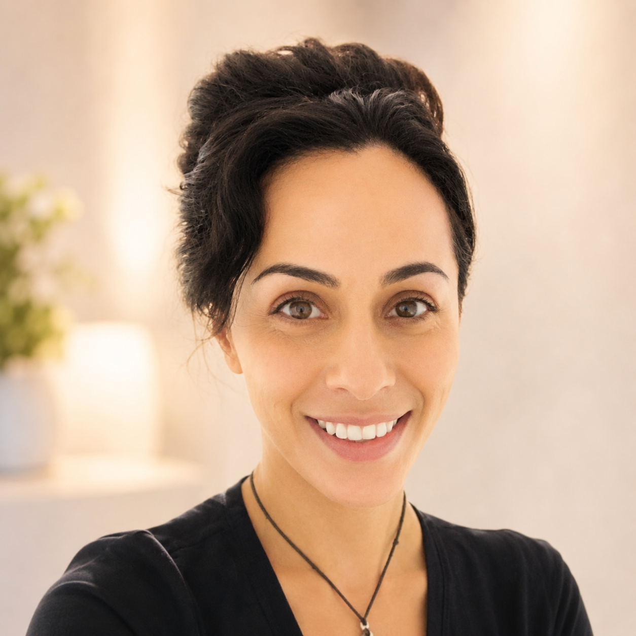 A woman with short dark hair and brown eyes smiling at the camera.