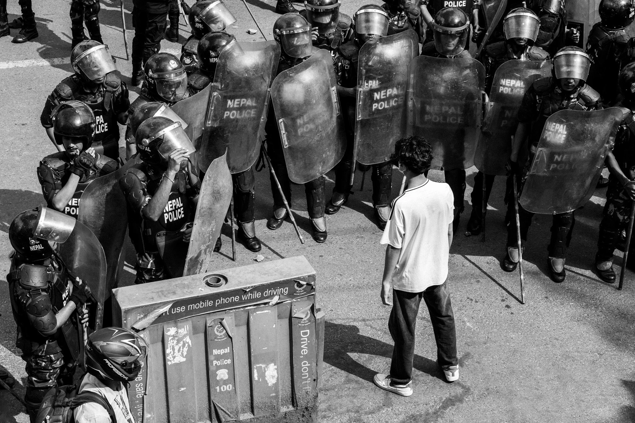 One white t-shirt. A wall of shields. Kathmandu, Nepal. 2025.