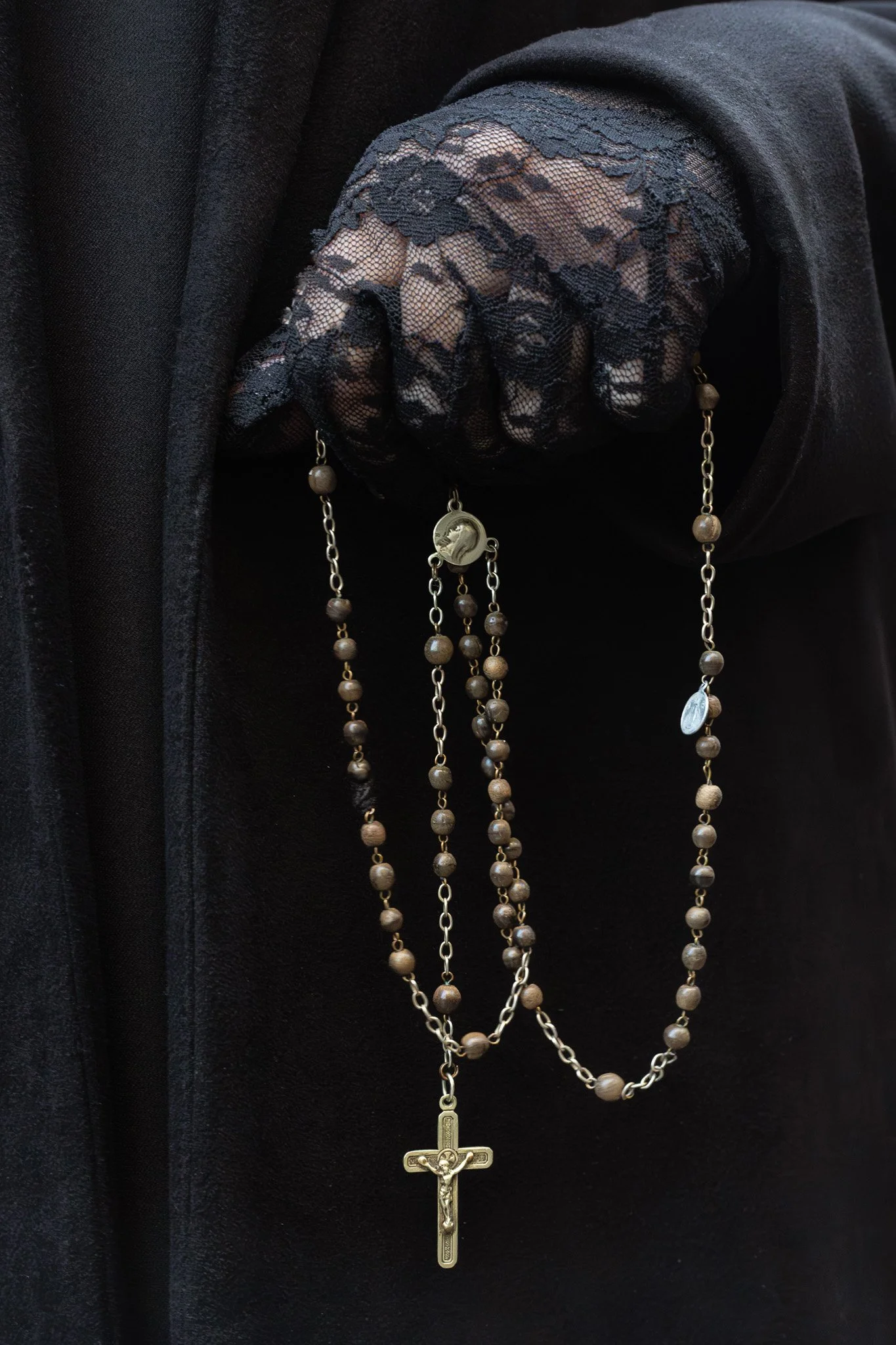 Mantilla Lace and chain and a small silver man on a cross. She has held this every year since she can remember.