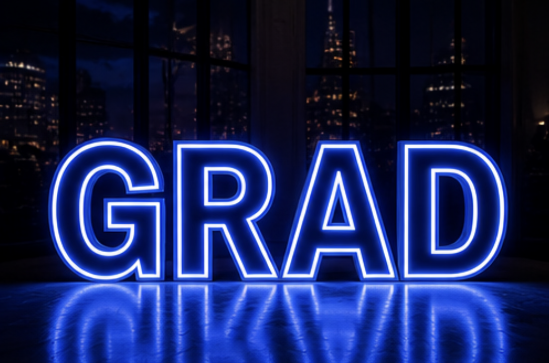 Neon sign spelling 'GRAD' with a city skyline in the background at night.