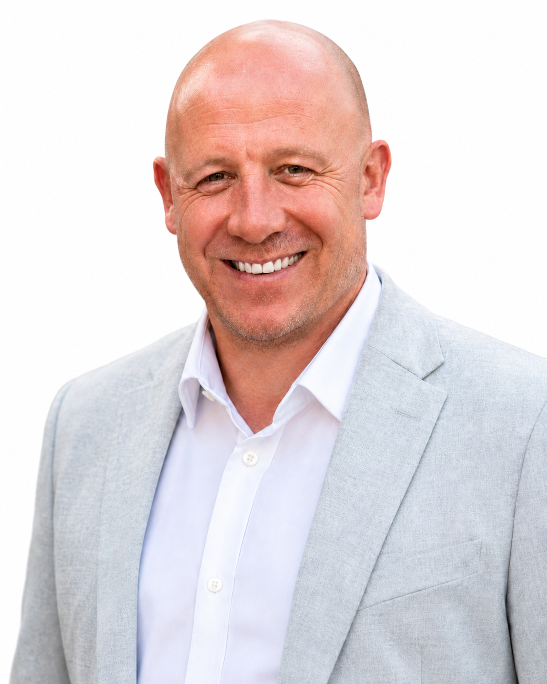 Headshot of a smiling, bald man wearing a light gray blazer and white shirt against a white background.