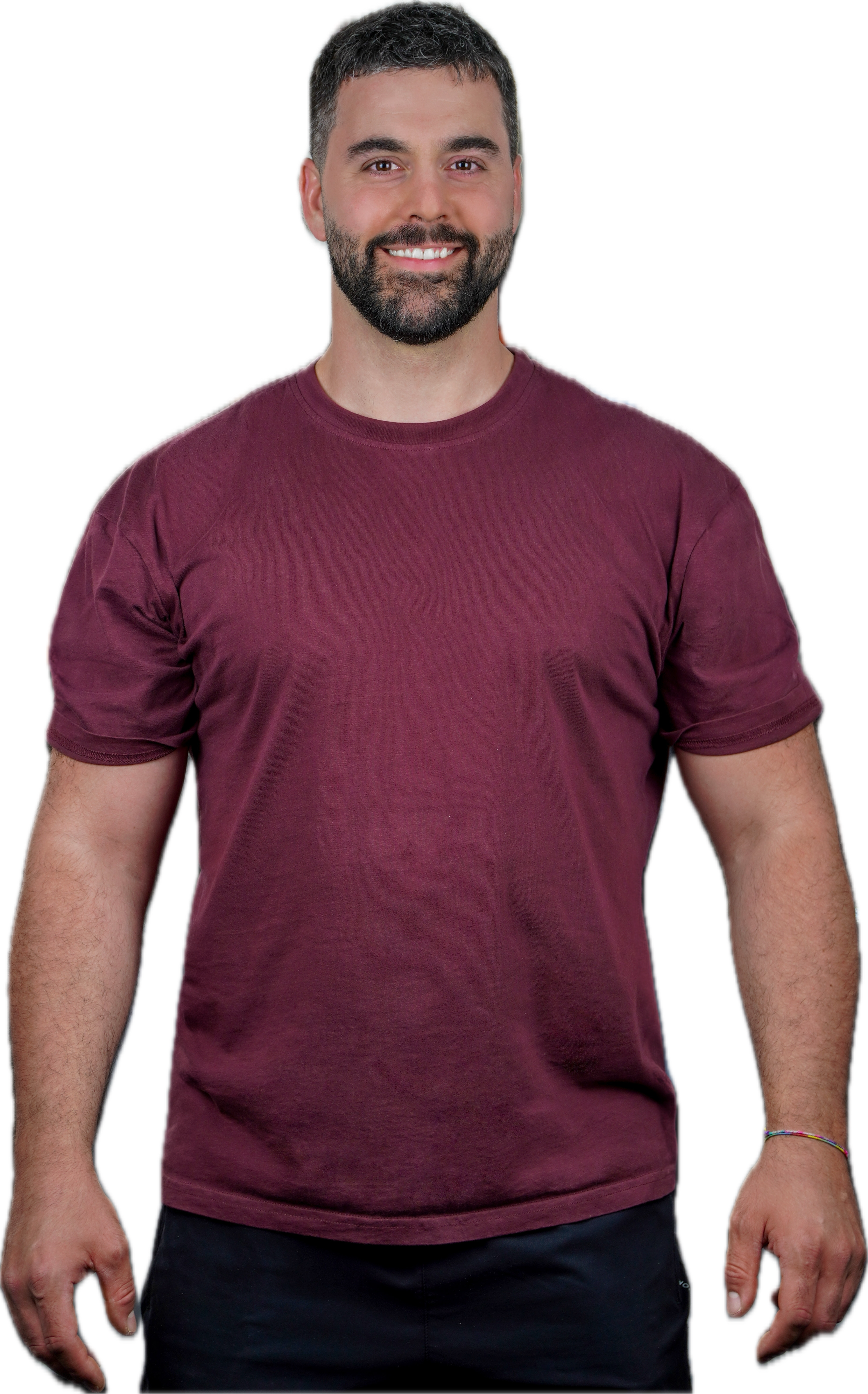 Uomo con barba e capelli corti, sorriso, maglietta color bordeaux, braccia rilassate, sfondo trasparente.