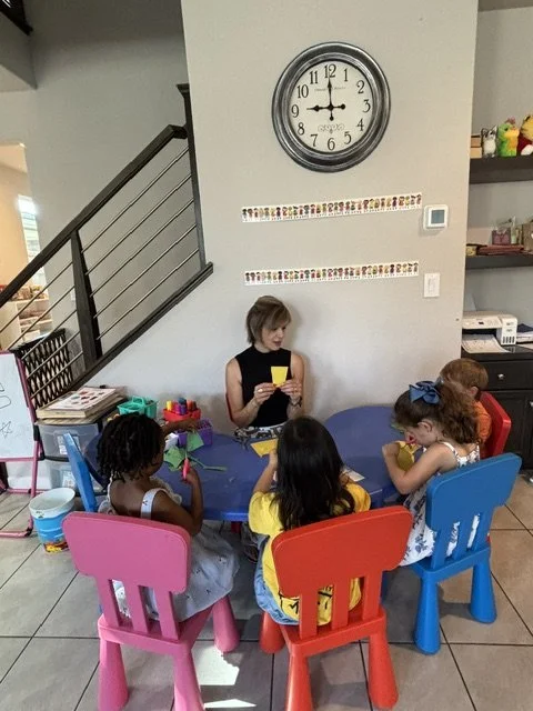 Preschool children participating in a small group hands-on learning activity with teacher guidance in a home daycare classroom