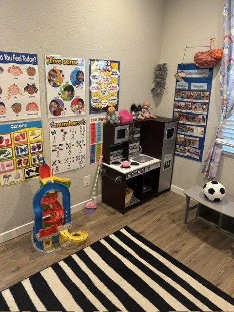 Preschool classroom with educational toys, play kitchen, and hands-on learning centers