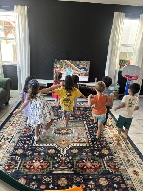 Bright indoor daycare playroom with toys, learning stations, and child-friendly activity areas