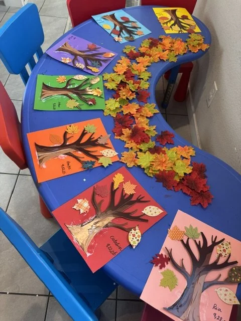 Colorful fall tree crafts created by preschool children during a seasonal learning activity at BabeeShark Preschool in Sacramento