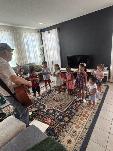 Preschool children participating in a music activity with an instructor while exploring rhythm, movement, and instruments at BabeeShark Preschool in Sacramento