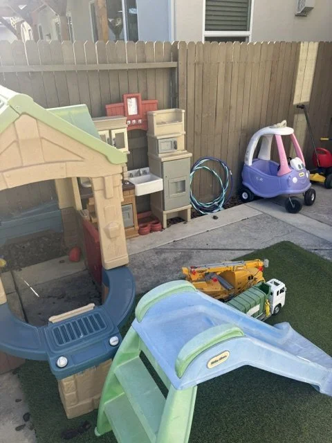 Outdoor toddler playground with slides, climbing equipment, and imaginative play activities