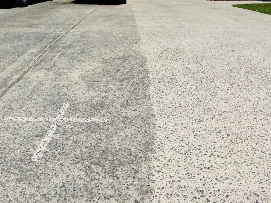 Comparison of two different concrete sidewalk surfaces, one weathered and dark, the other new and light from soft washing